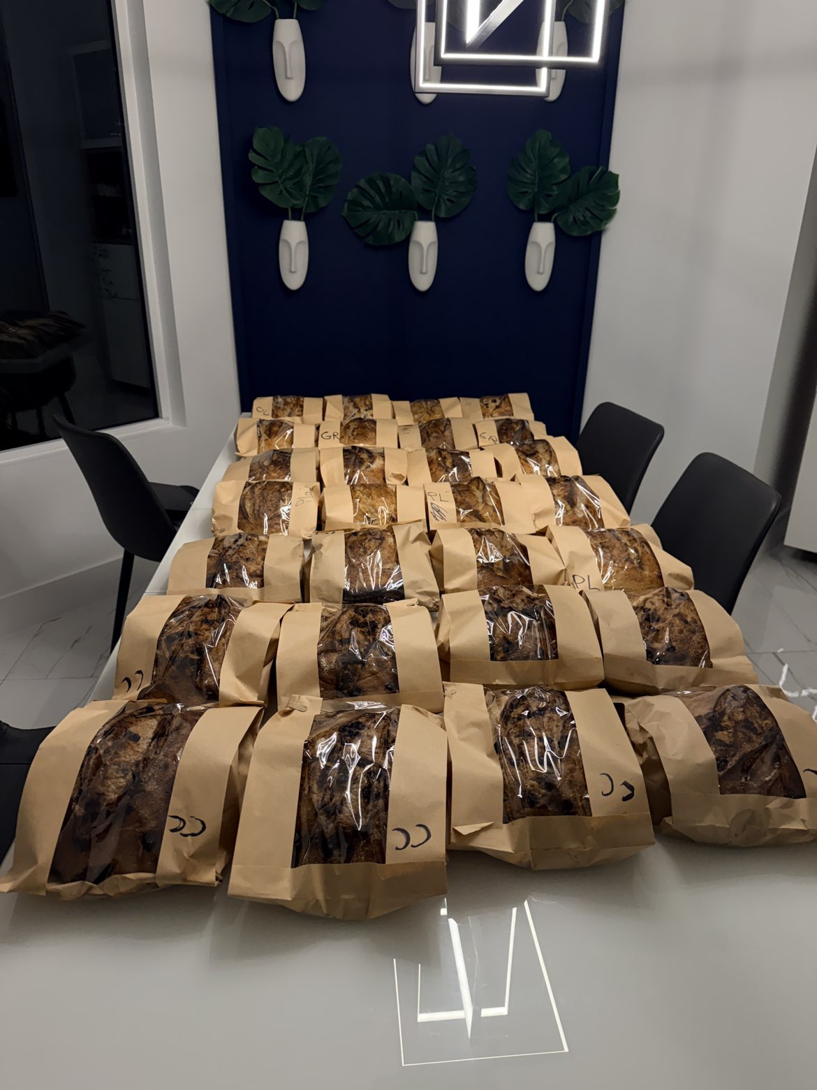 A table filled with wrapped sourdough loaves ready for pickup